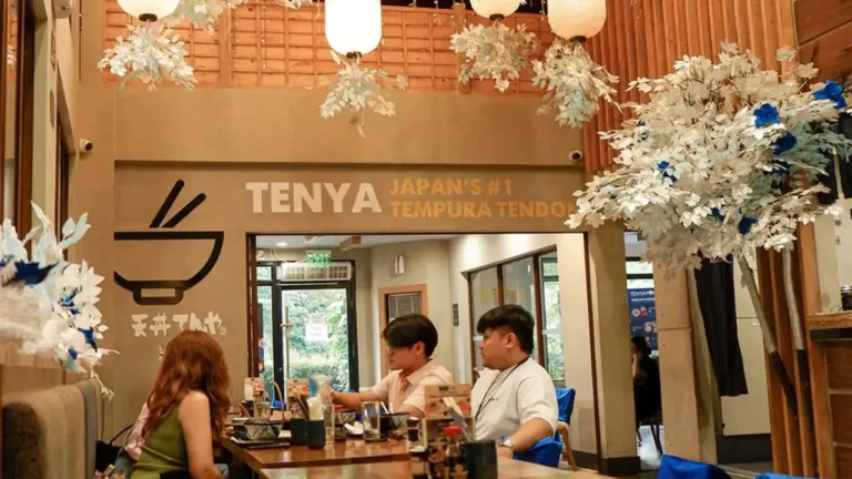 People sitting on the food table of food, a menu of tenya philippines resturant.